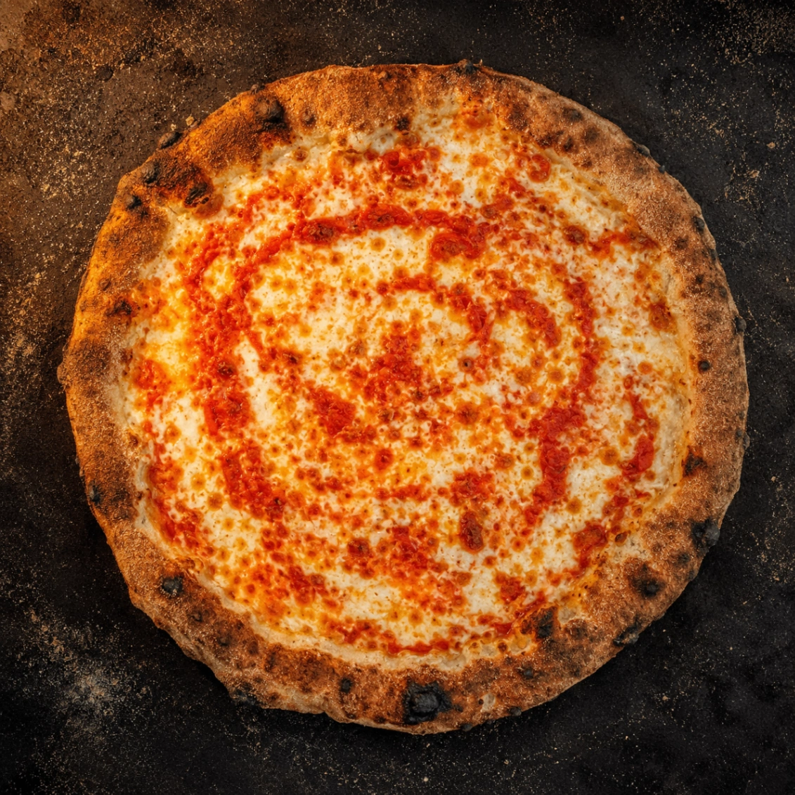 Top-down view of The Maruca wood-fired cheese pizza with a swirl of homemade red sauce